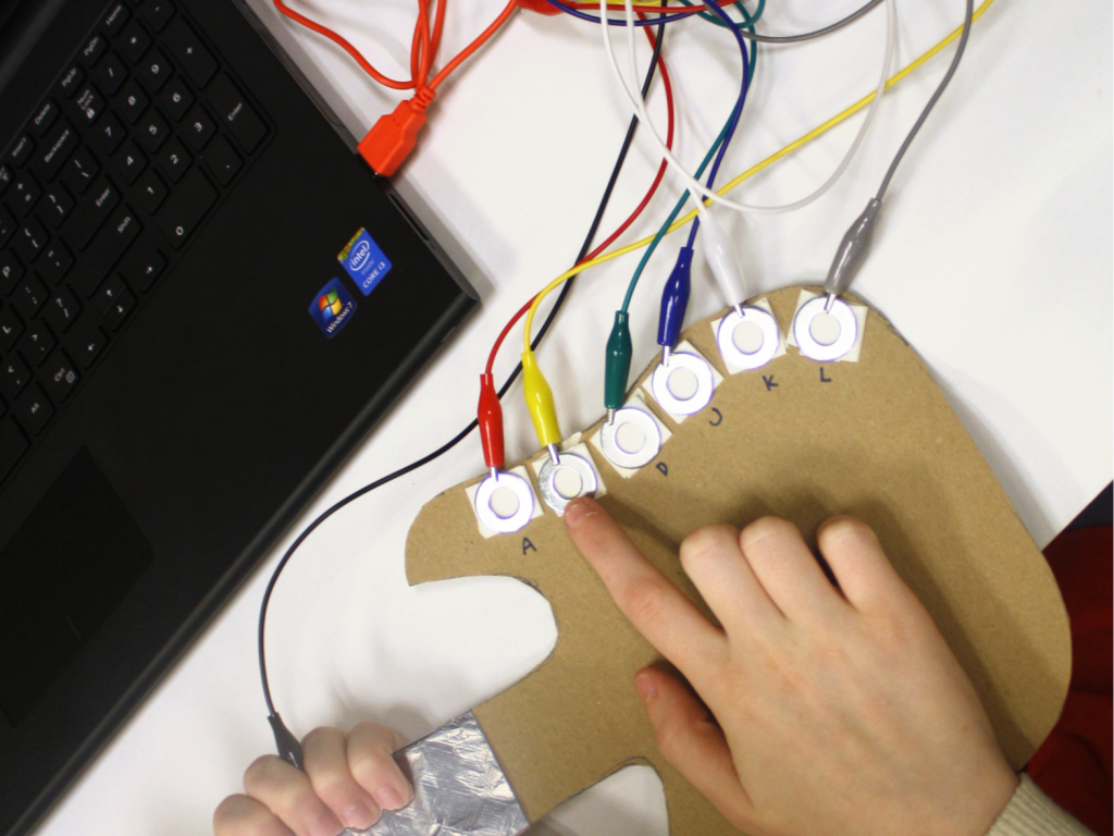guitar made from cardboard with conductive materials placed onto it so that it can be plugged into a laptop to make music